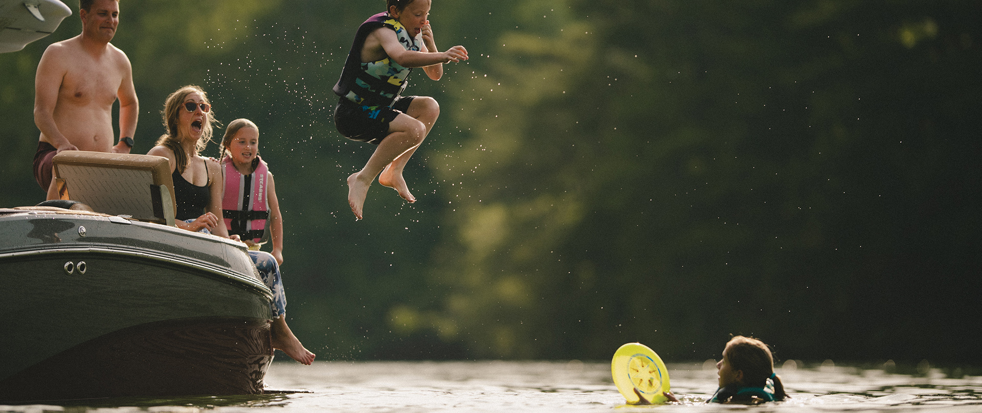 Kid jumping off of Mastercraft Boat